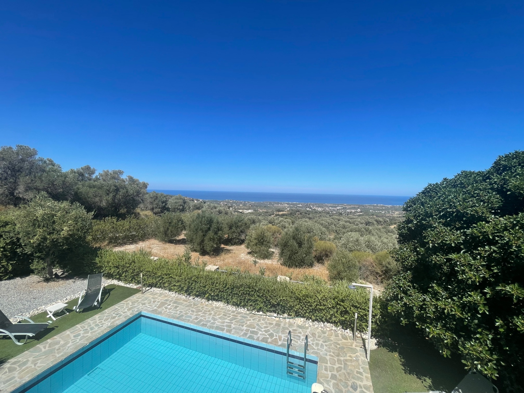 Pool framed by hedges overlooking the Cretan Sea
