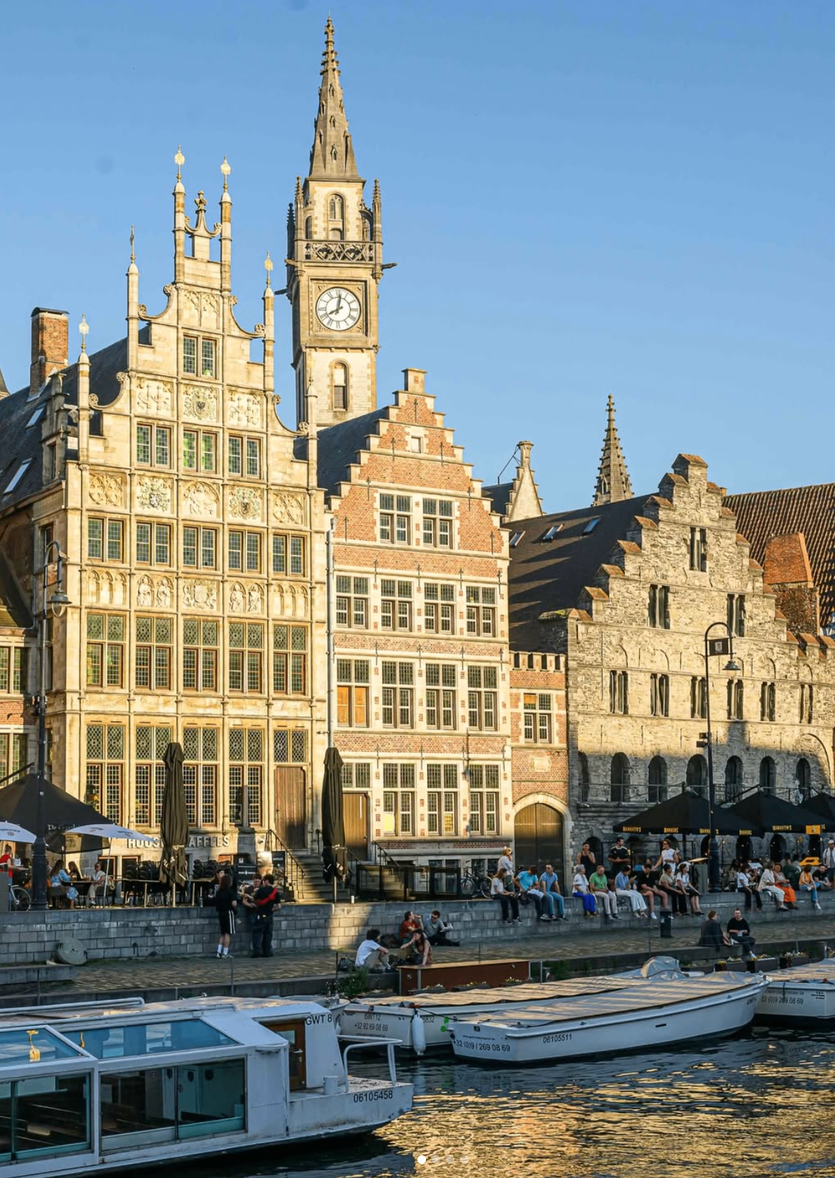 Editorial photograph of Ghent canal at golden hour, medieval architecture reflected in the water